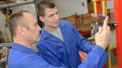Plumbing teacher encouraging apprentice Plumbing teacher encouraging apprentice