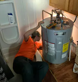 Cole Kotouc performing a water heater installation. Cole Kotouc performing a water heater installation.