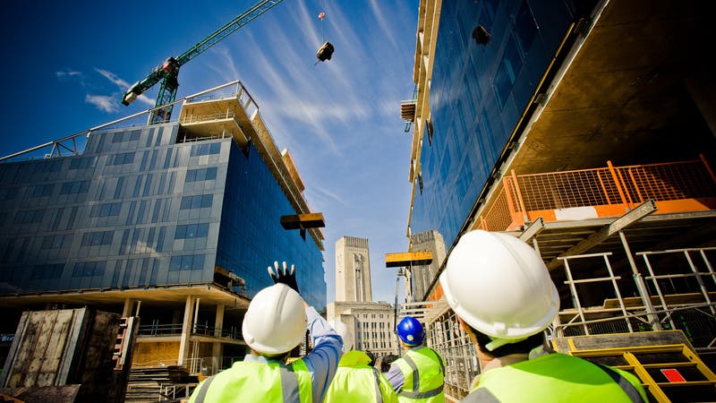 Building under construction with workers.