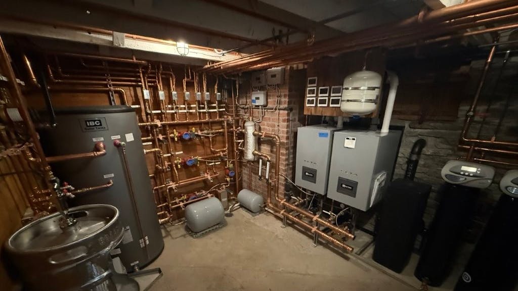 The basement mechanical room, complete with two ALTA boilers, a 120-gallon indirect tank and (lower left corner) a beer keg urinal.