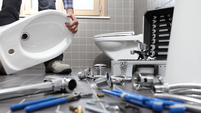 plumber installing a toilet