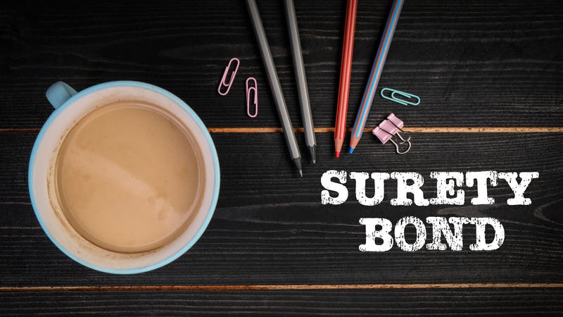 SURETY BOND. Black wood texture office desk.