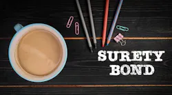 SURETY BOND. Black wood texture office desk.