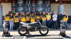 A group photo of the build team, with one of the converted motorcycles.