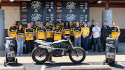 A group photo of the build team, with one of the converted motorcycles.