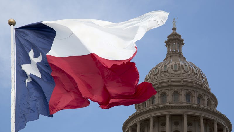 Texas state flag, with the dome of the State Capital in Austin.