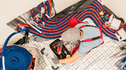 technician installing radiant underfloor heating