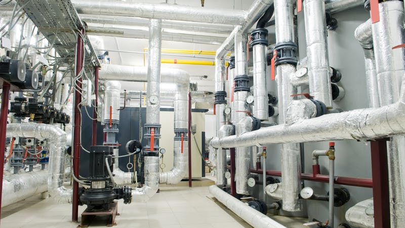 modern gas boiler room with manometers, valves, pumps and thermo-insulation on pipelines
