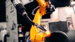 Robot arm welding metal pipe.