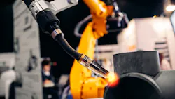 Robot arm welding metal pipe.