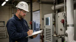 project manager in a mechanical room with clipboard