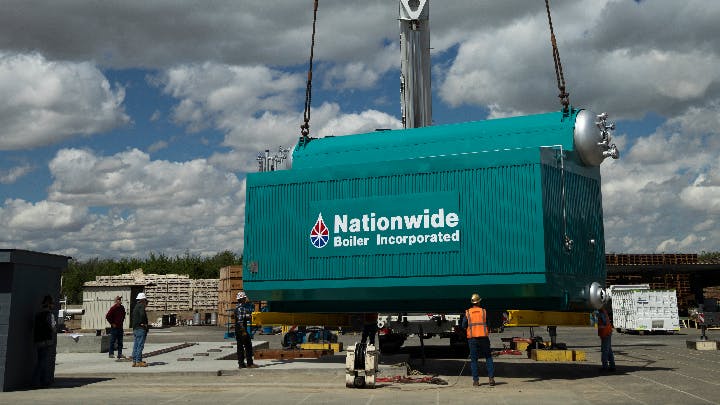 A boiler being crane-lifed.