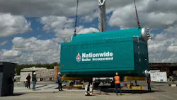 A boiler being crane-lifed.