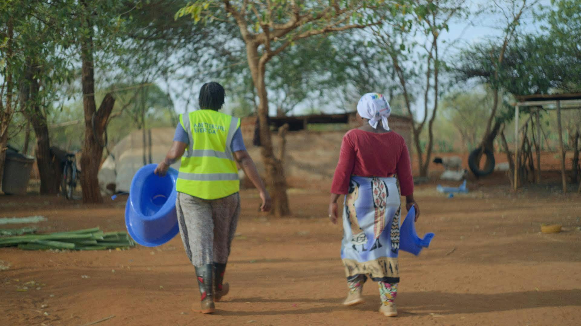two women walking away from the camera in a rural setting