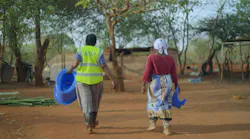 two women walking away from the camera in a rural setting