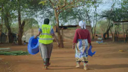 two women walking away from the camera in a rural setting