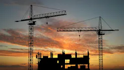 construction cranes at sunset