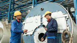 Two technicians perform a boiler inspection.