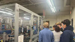 Students at APCOM's Franklin facility observe a manufacturing robot in operation.